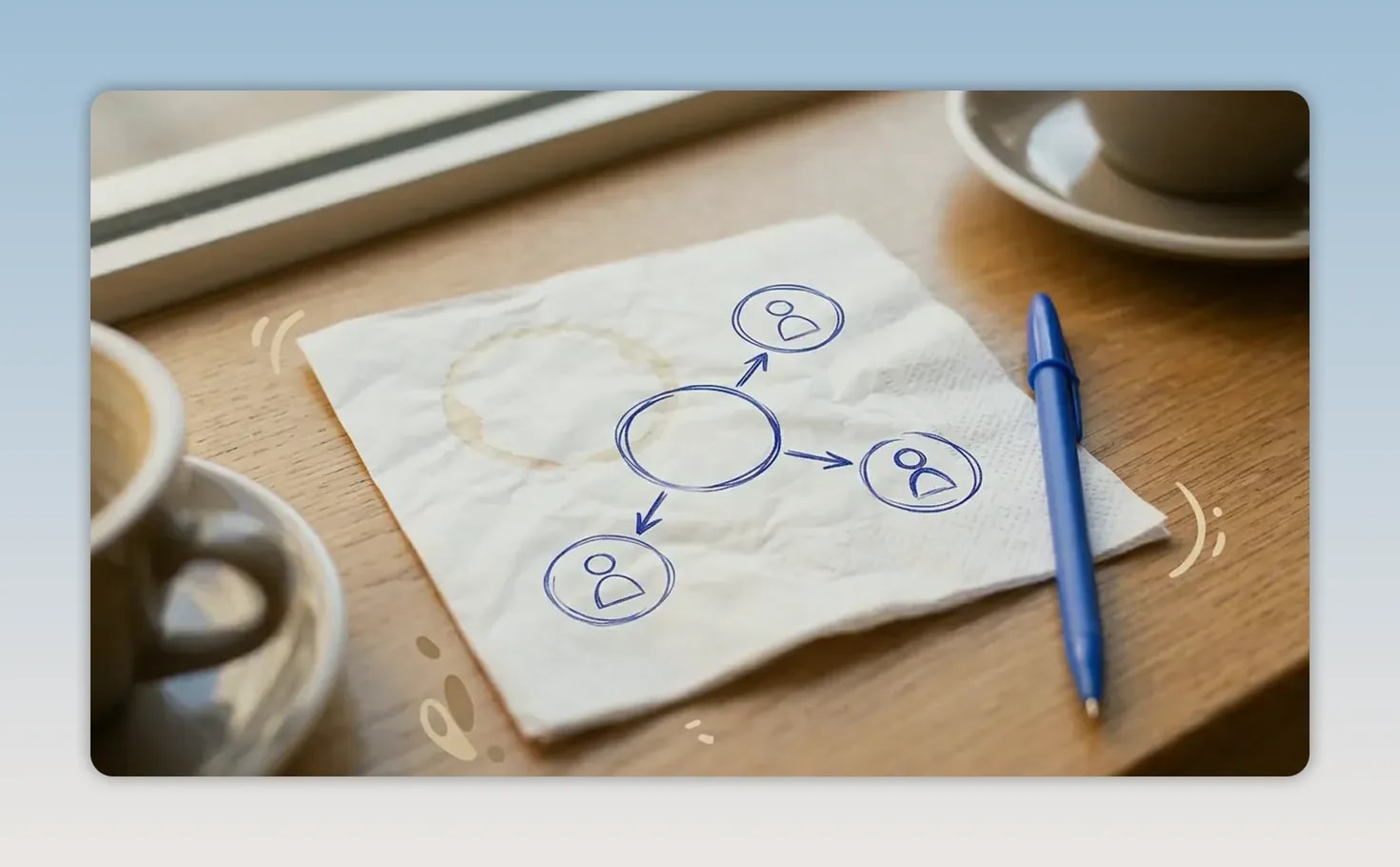 A napkin with a hand-drawn branching diagram of connected people beside a blue pen